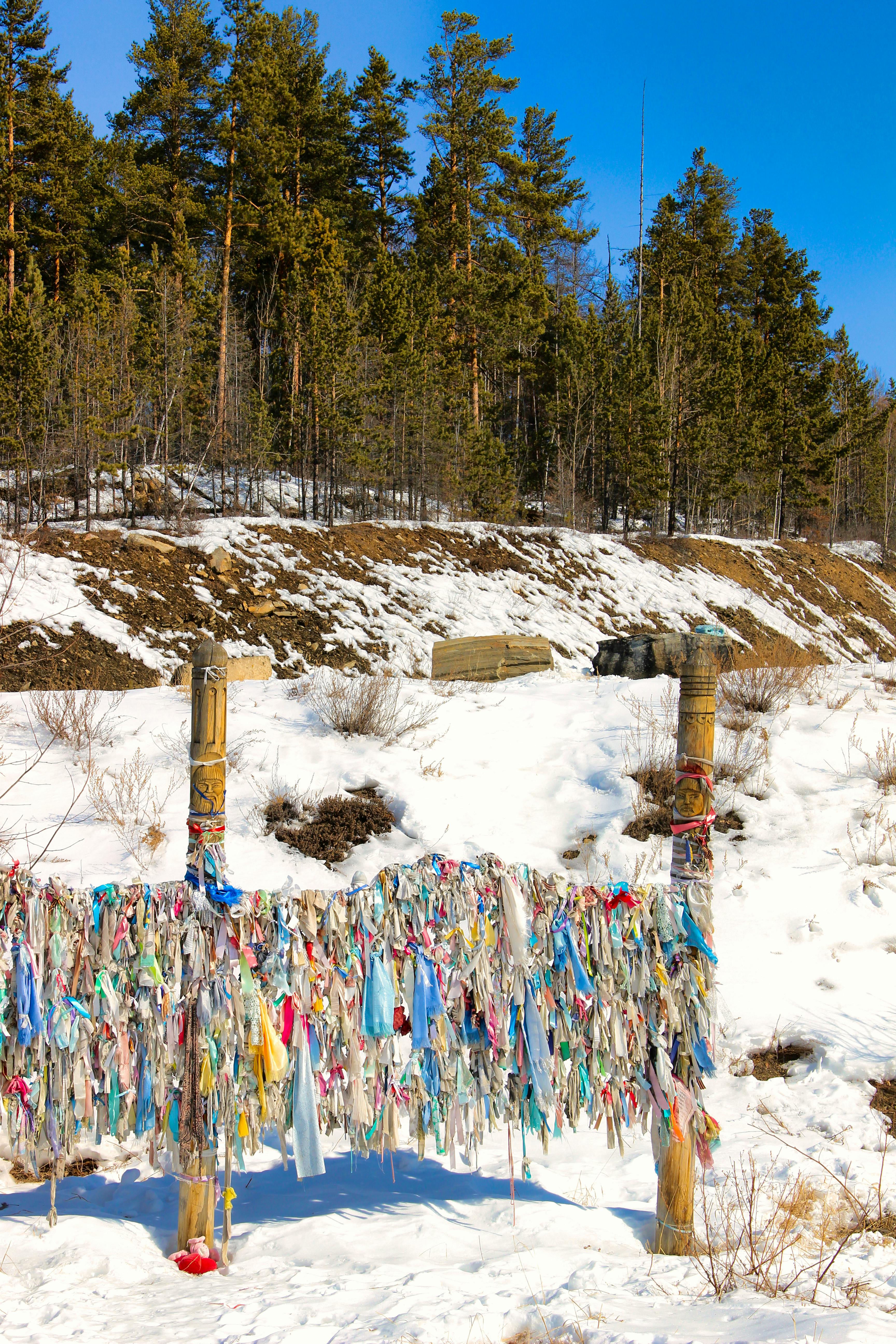 a fence covered in plastic bags in the snow