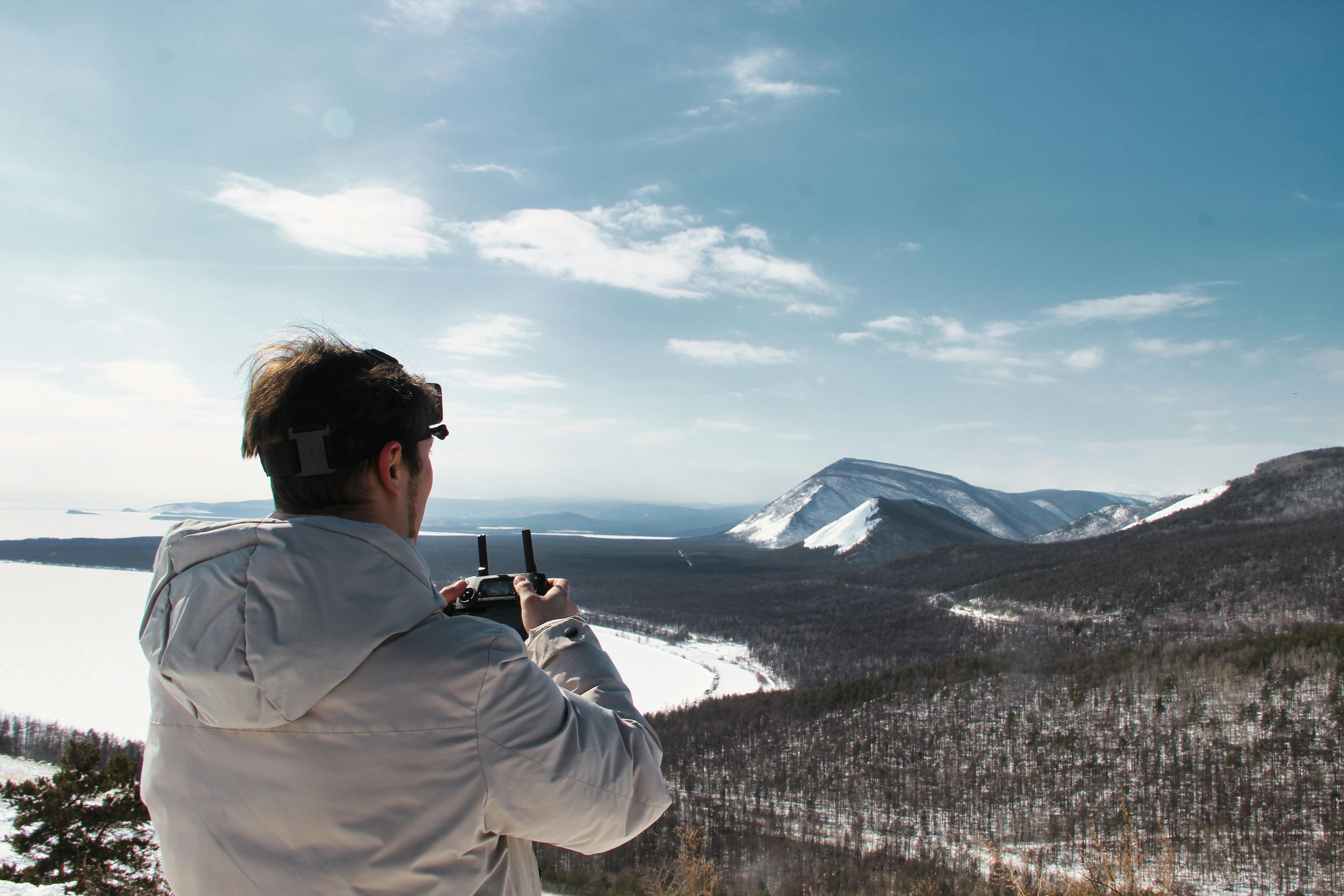 a man taking a picture of the snow covered mountains