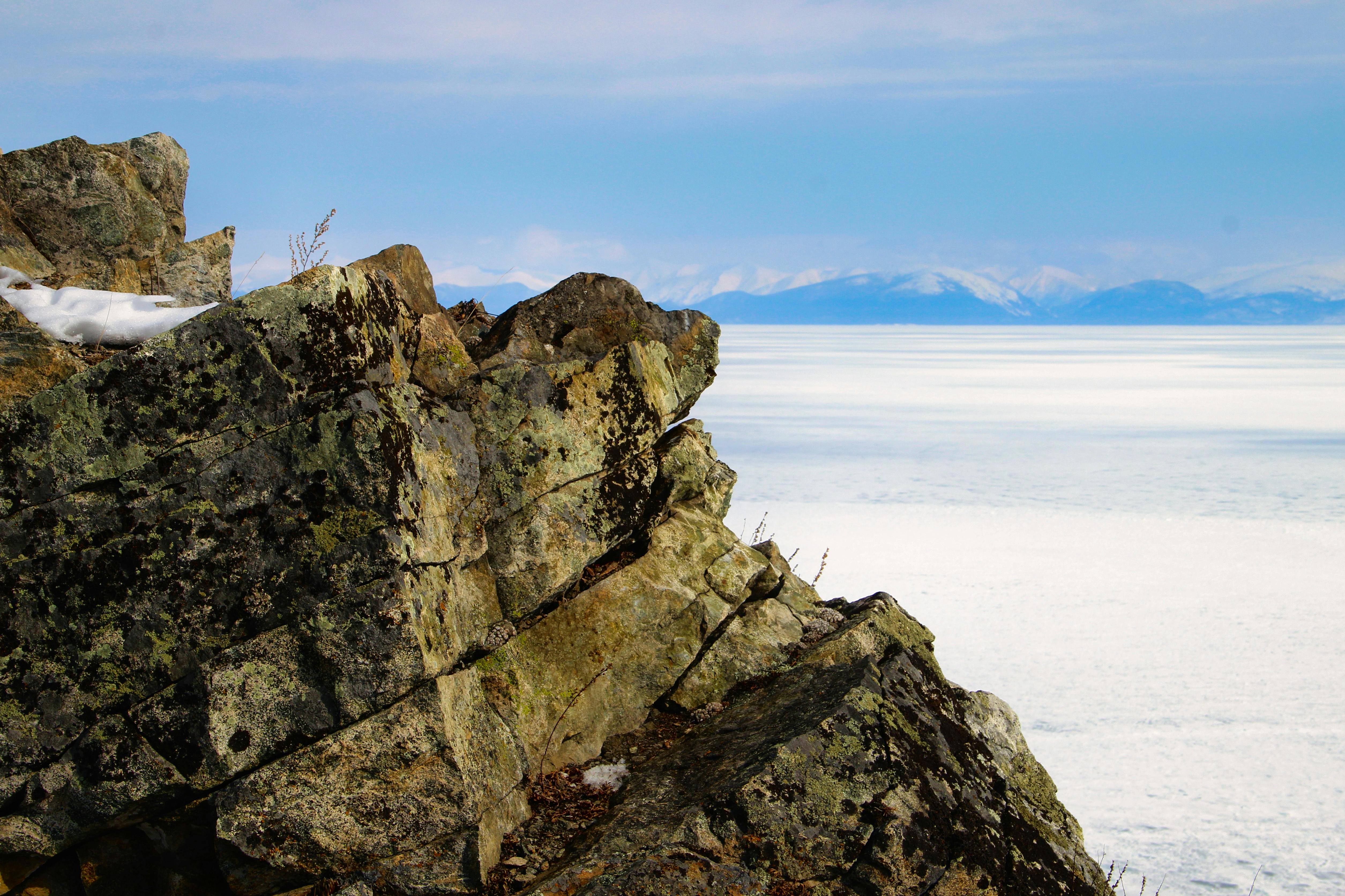 a person standing on top of a rock overlooking the ocean