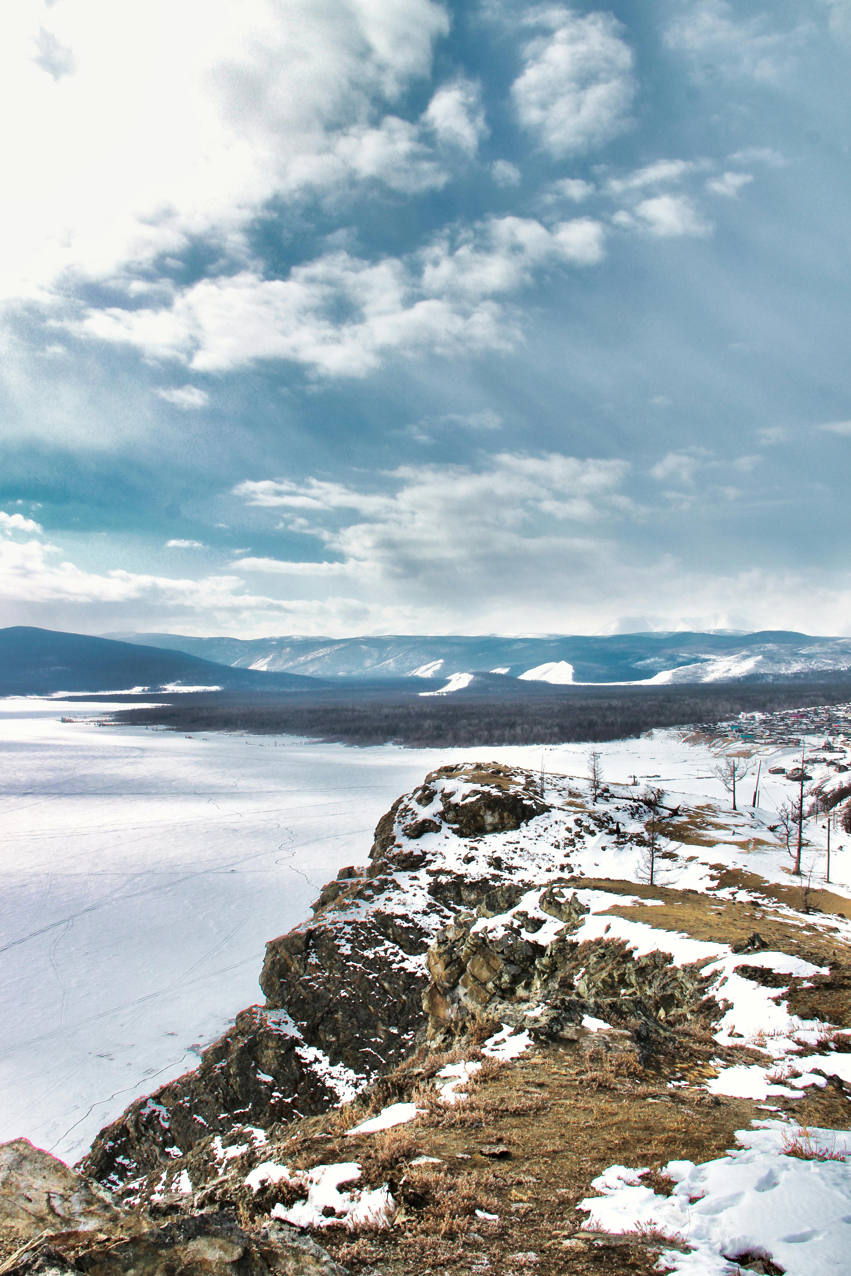 a view of a snowy landscape with a mountain in the background