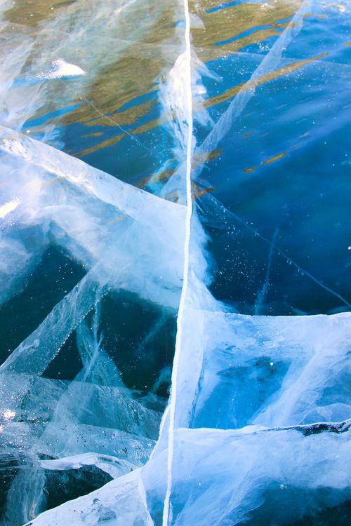 Free Intricate cracks on a frozen lake surface showcasing the beauty of winter ice formations. Stock Photo