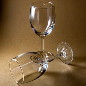 Two empty wine glasses in a minimalist studio setup, showcasing elegance and simplicity.