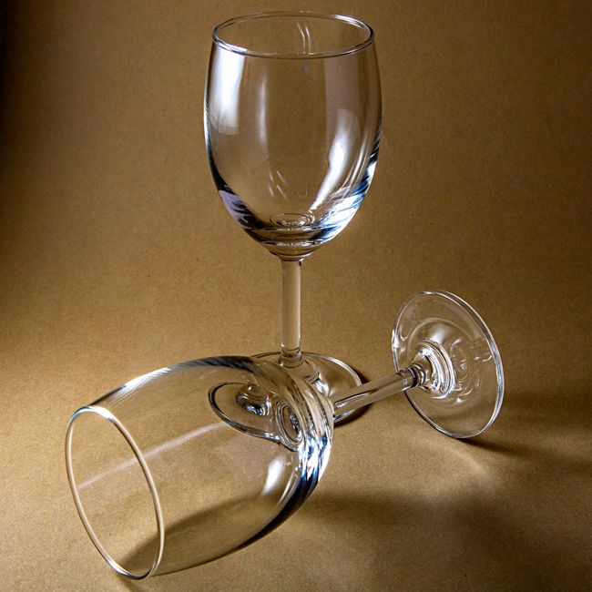 Two empty wine glasses in a minimalist studio setup, showcasing elegance and simplicity.