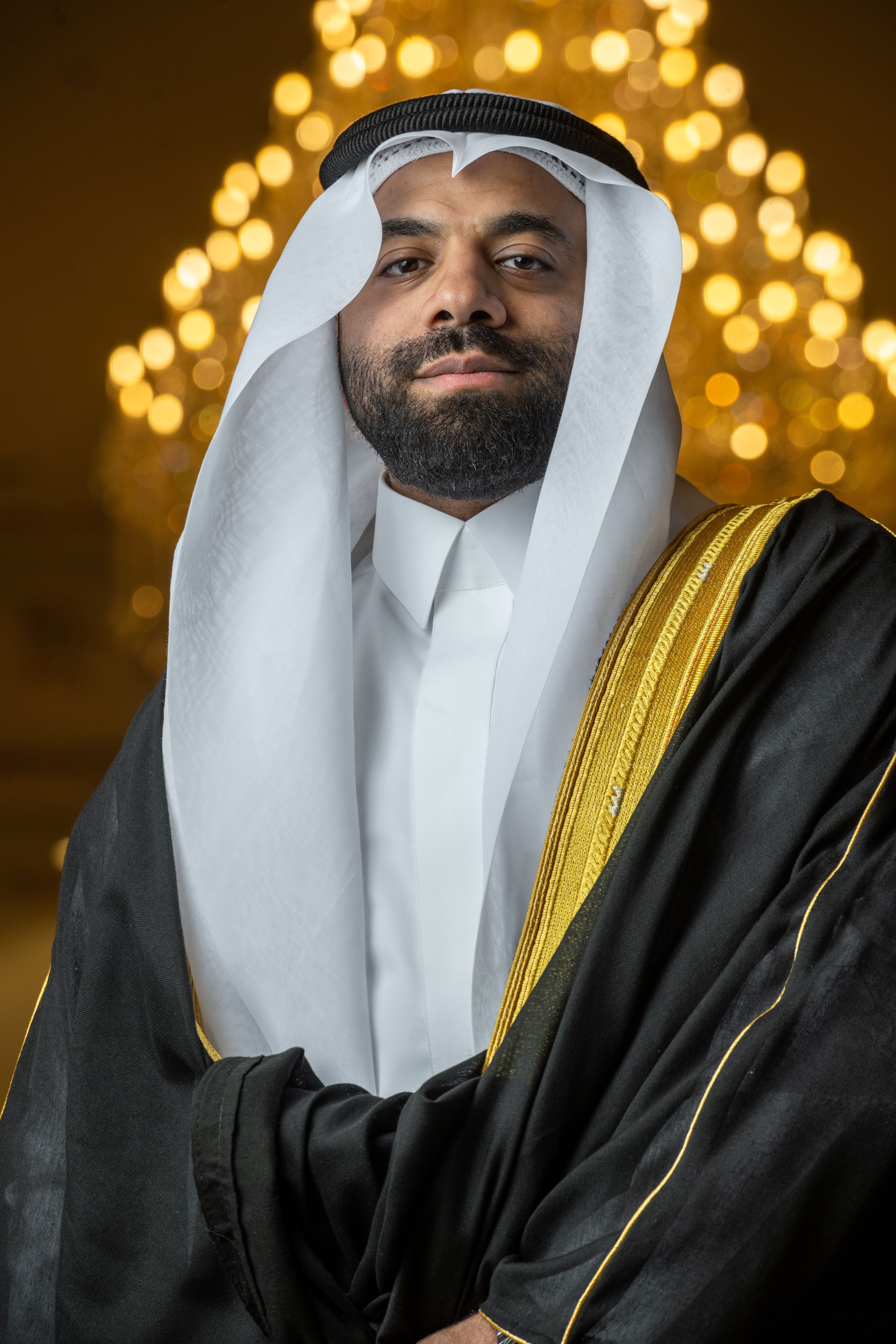 A dignified portrait of a man in traditional Middle Eastern attire against a glowing backdrop.