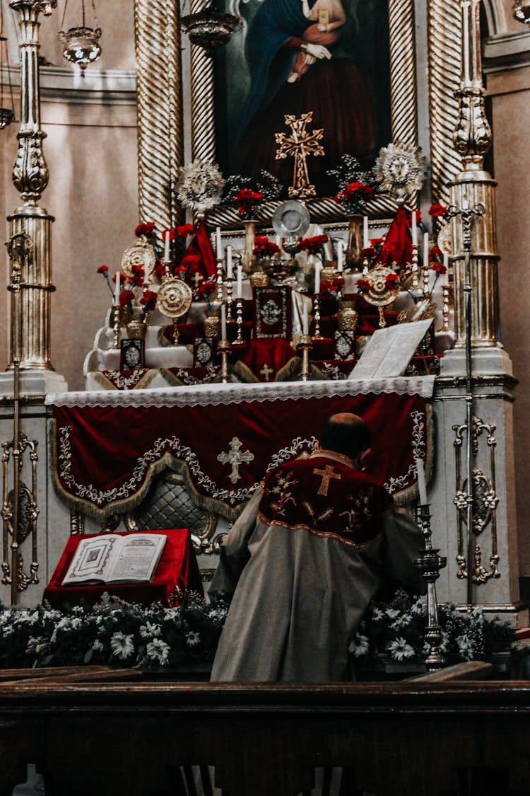 Back View Of A Priest Standing At The Altar During A Sermon