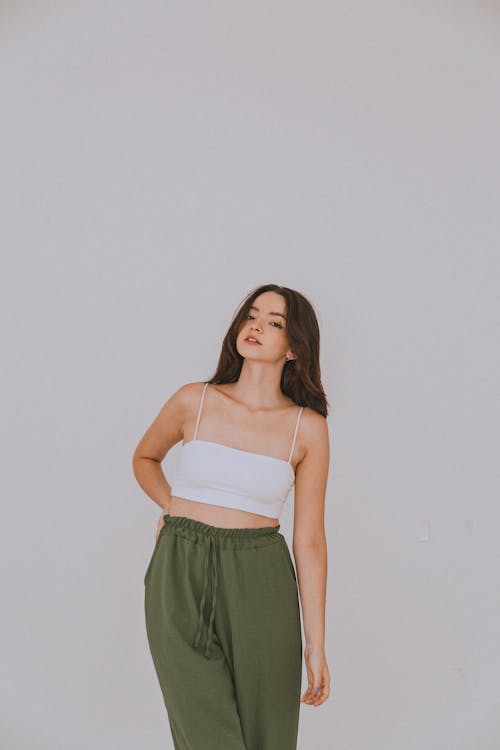 Studio Shot of a Young Woman in a White Crop Top and Khaki Trousers