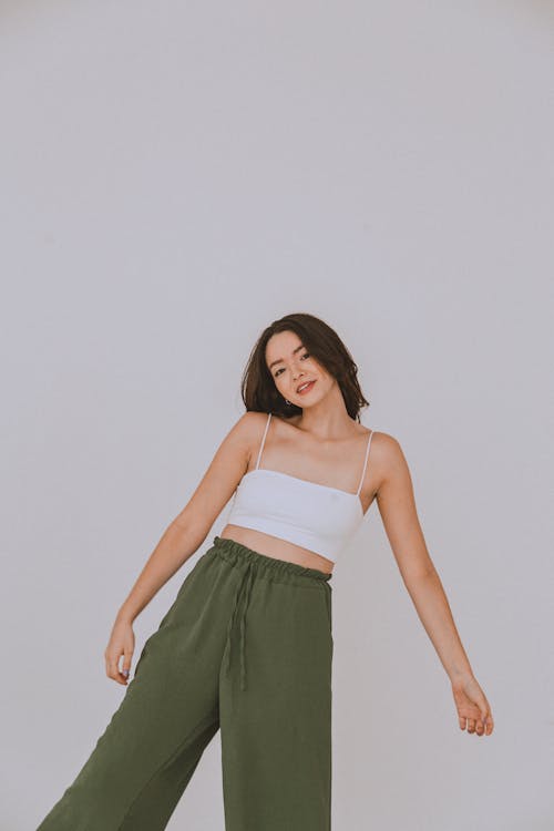 Studio Shot of a Young Woman in a White Crop Top and Khaki Trousers 