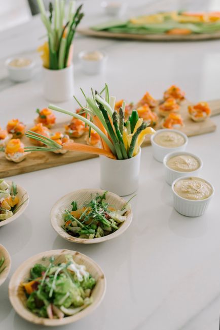 A high-angle view of a gourmet vegetable and sushi appetizer spread with dipping sauces.