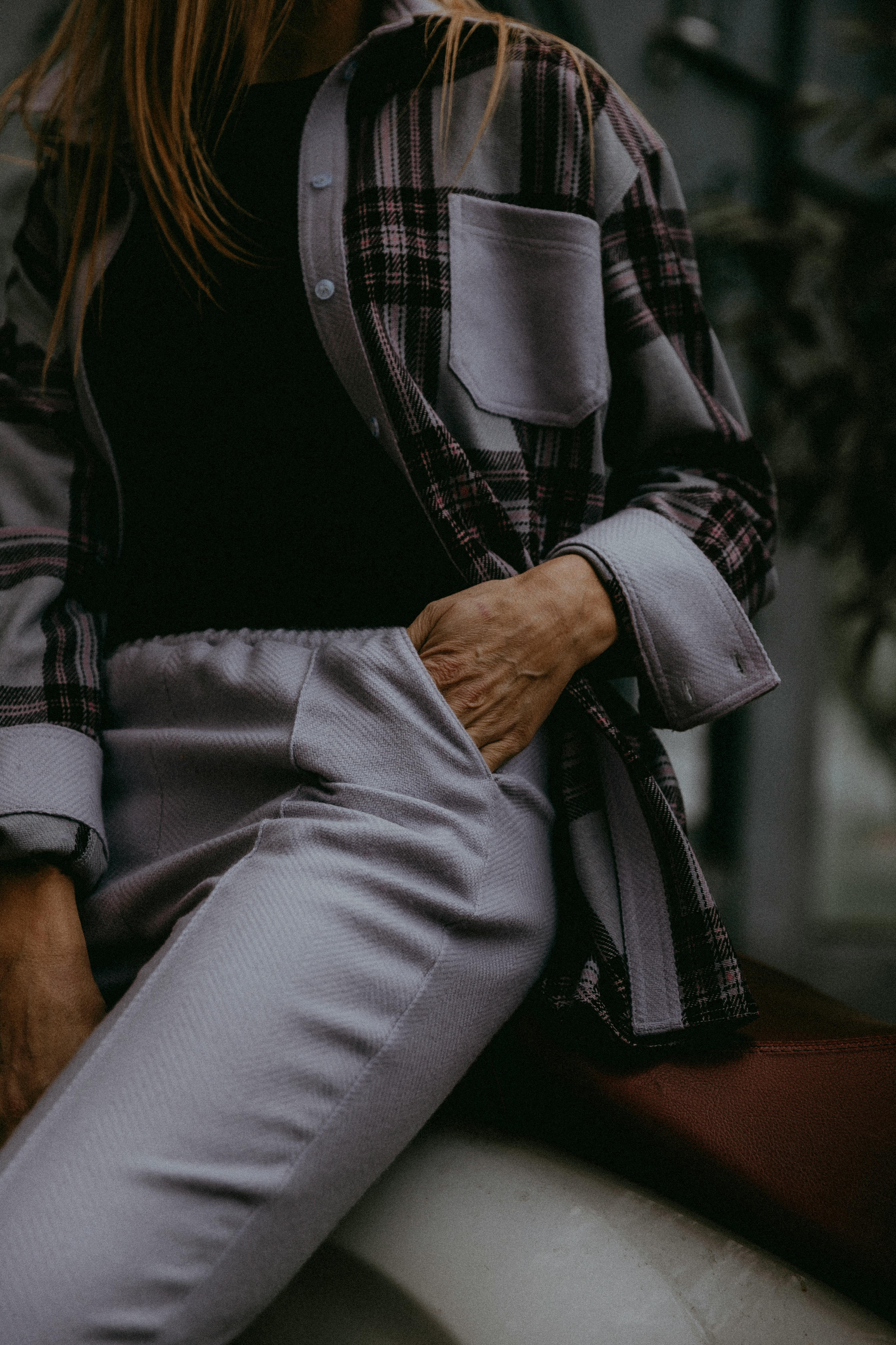 Free A stylish individual in casual attire seated indoors for a fashion photo. Stock Photo