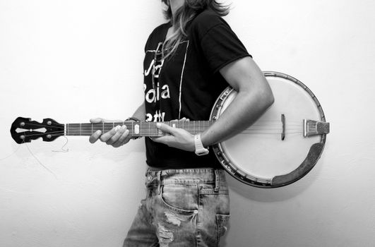 Grayscale Photo of Man Holding Banjo Guitar