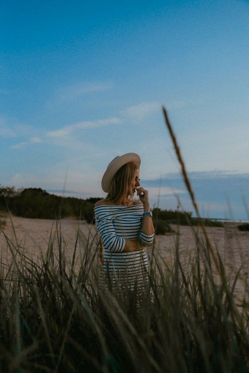 Woman in a Straw Hat Sitting on a Sandy Beach · Free Stock Photo