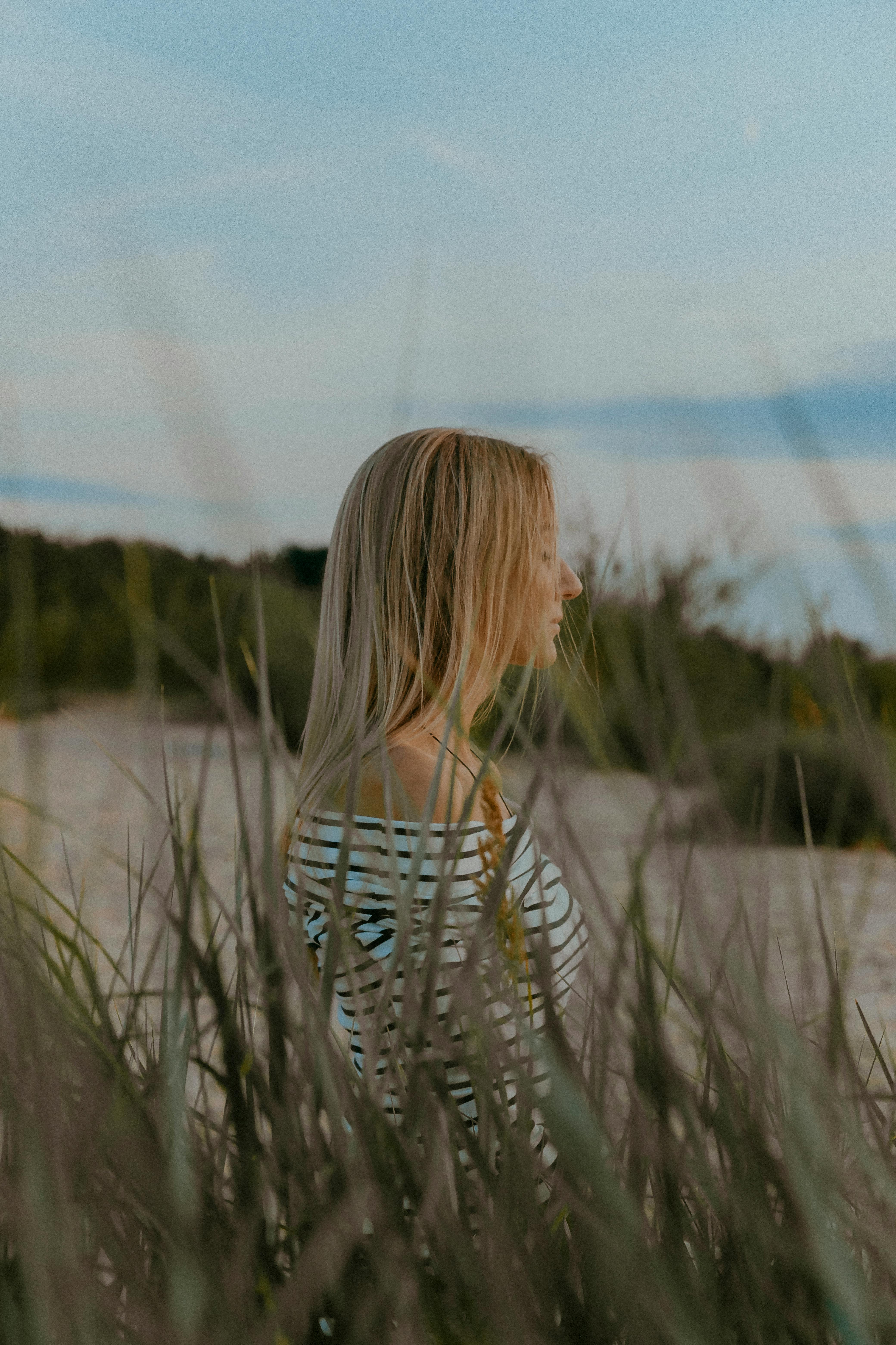 Blonde Woman behind Grasses · Free Stock Photo