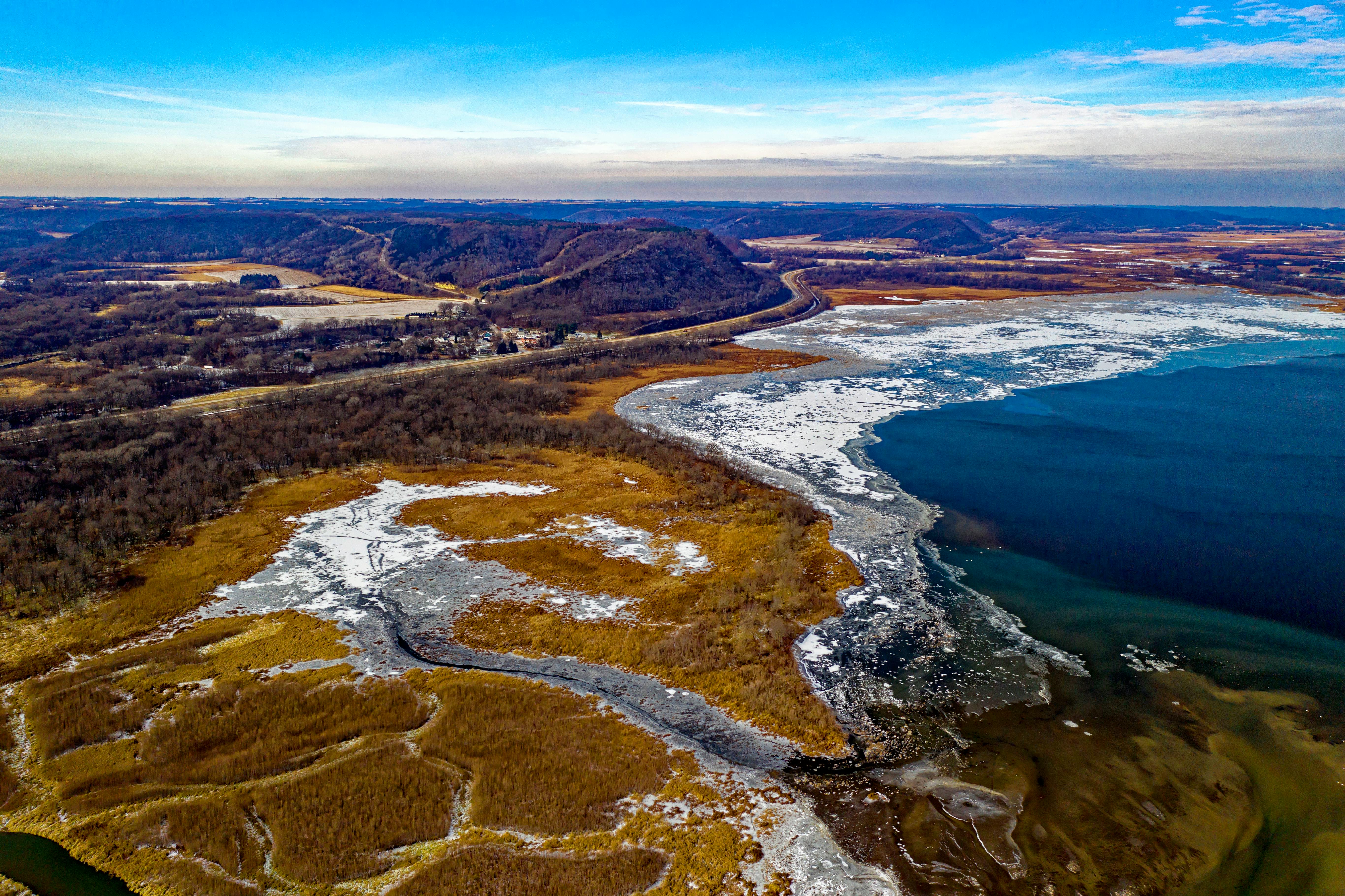 aerial view of body of water land formation and mountain