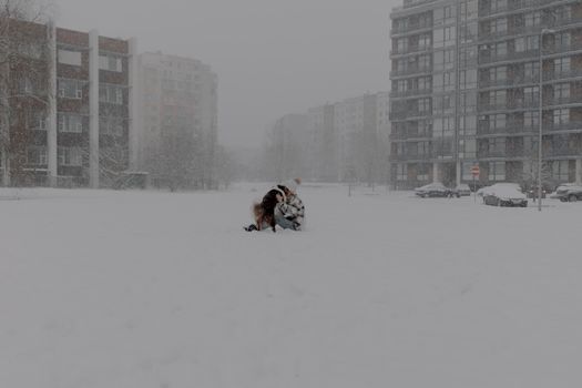 A Girl Playing with a Dog Outdoors in Winter