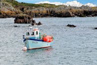 宁静的岩石海湾里，充满活力的渔船与浮标静静停泊