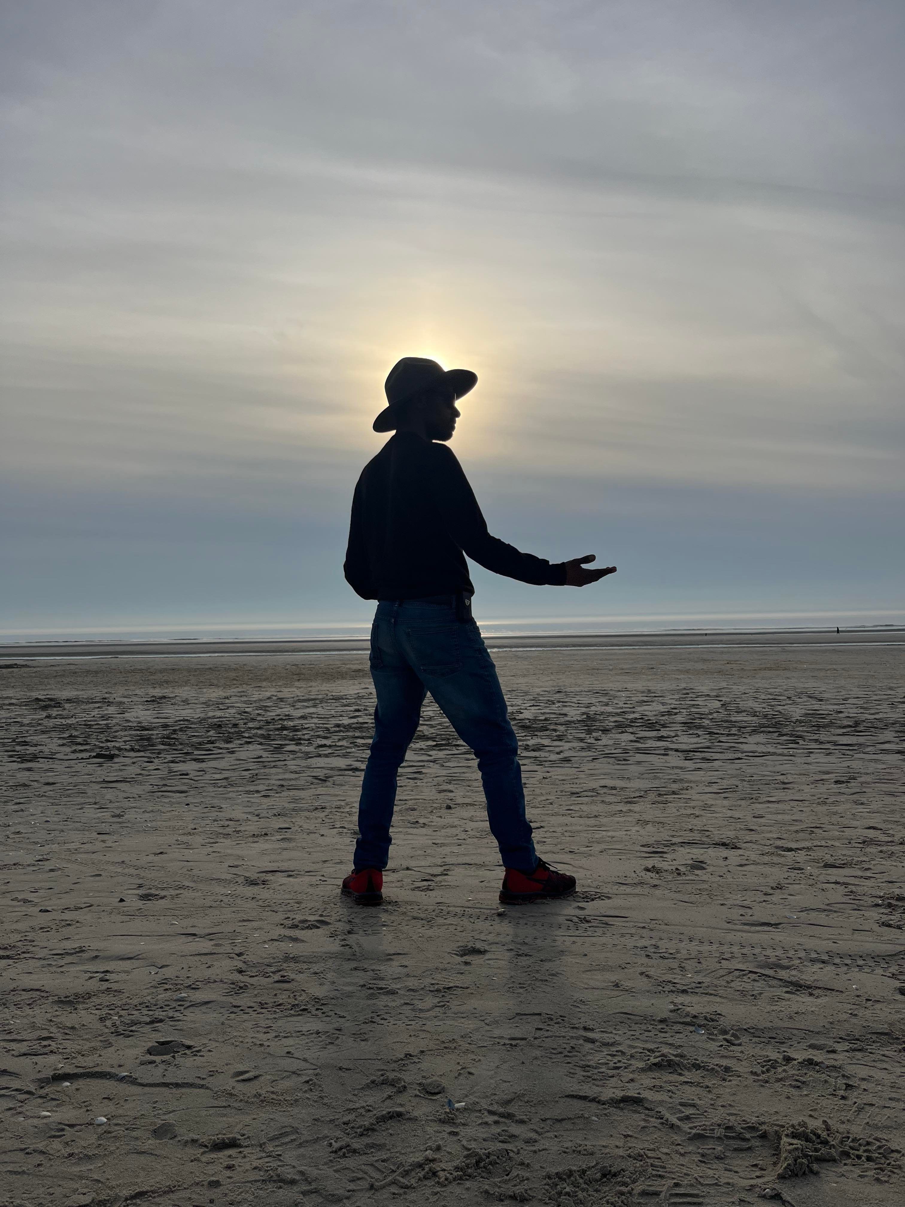A Silhouette of a Man on the Beach at Sunset · Free Stock Photo