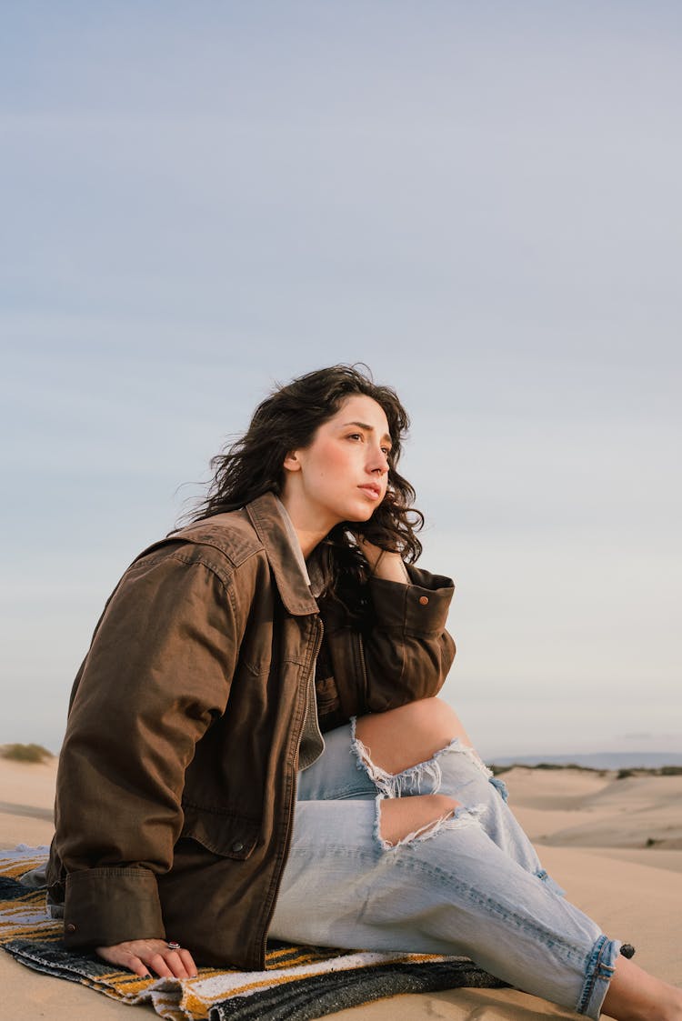 Woman Sitting On Towel On Sand