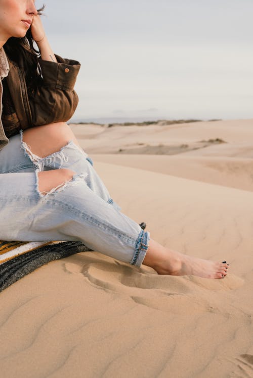 Free Woman Sitting on Sand Stock Photo