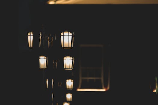 A series of warm glowing street lamps at night create a cozy, moody ambiance.