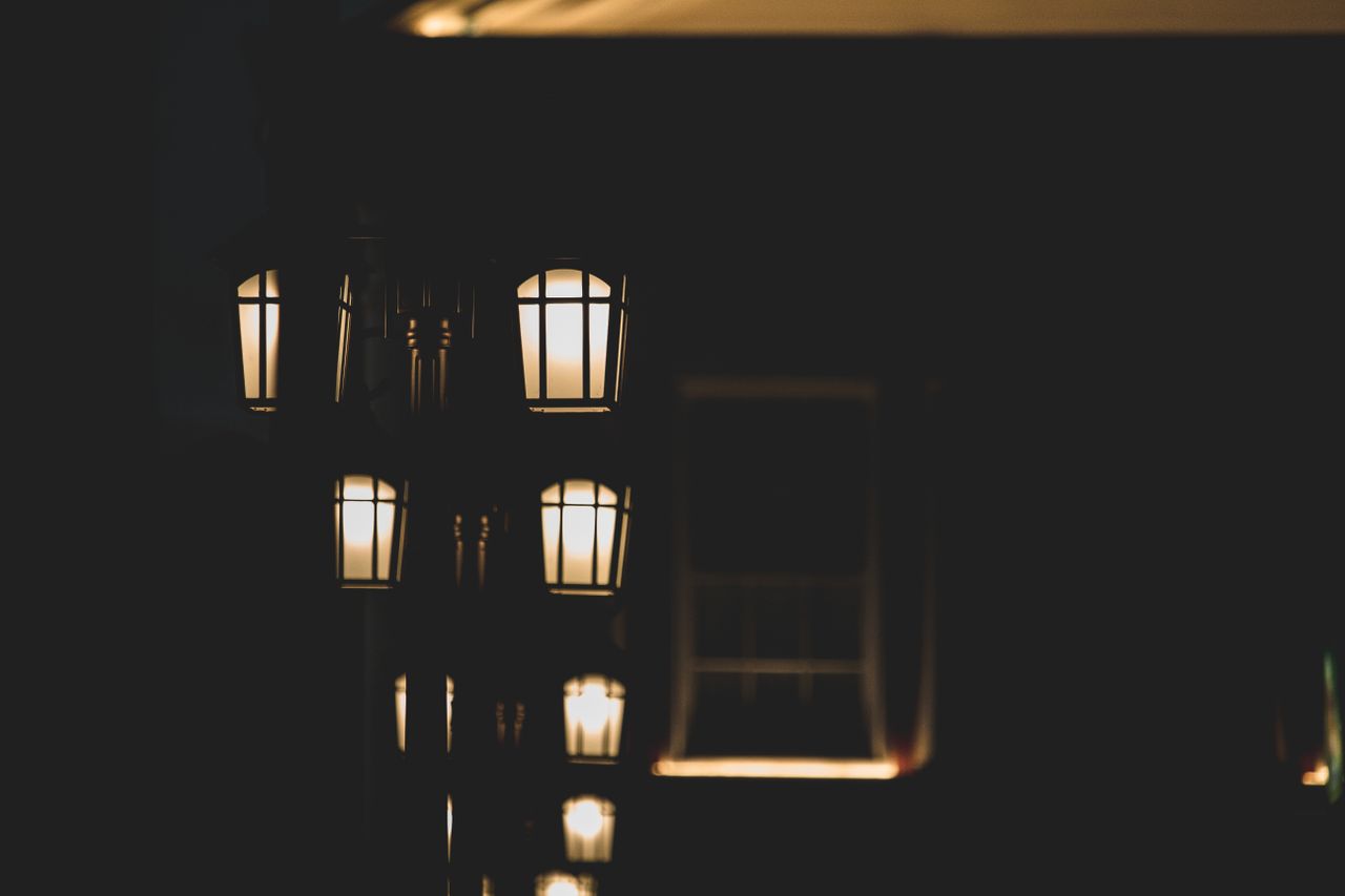 a series of warm glowing street lamps at night create a cozy moody amb