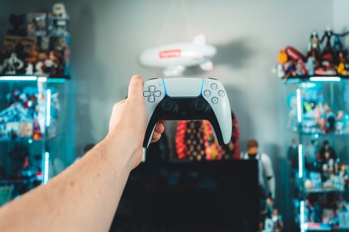 Free A person holding a gaming controller in a vibrant game room setting. Stock Photo