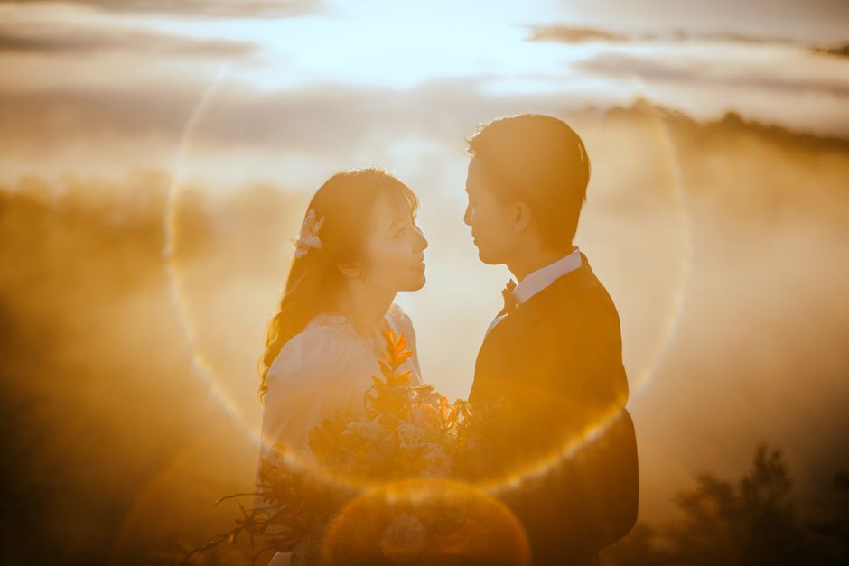 couple bathed in warm, glowing light of a sunset wedding photo - golden hour wedding photos