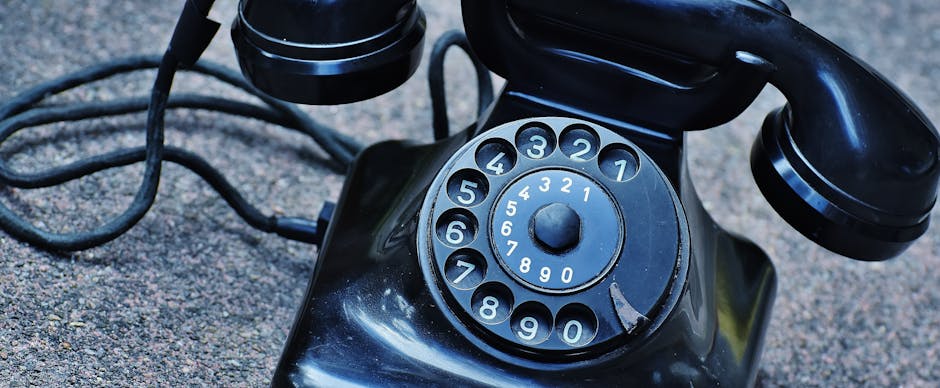 Black Rotary Telephone at Top of Gray Surface