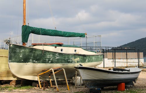 Boat and Sailboat on Ground