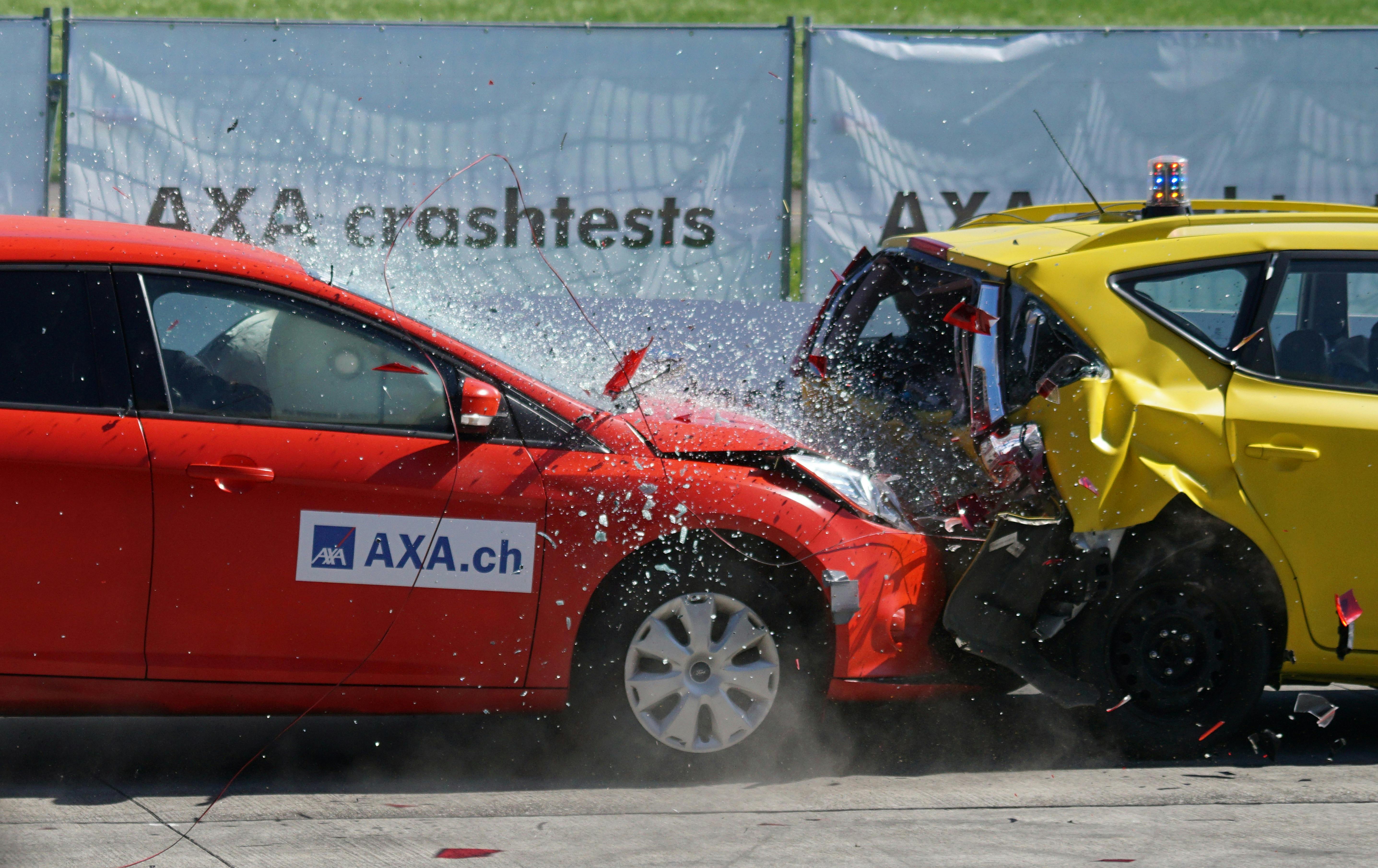 The red car collides with the yellow one, prompting the airbag impact sensor.