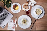 头顶镜头通过笔记本电脑的膳食设置，展示了舒适室内环境中的食物与生产力