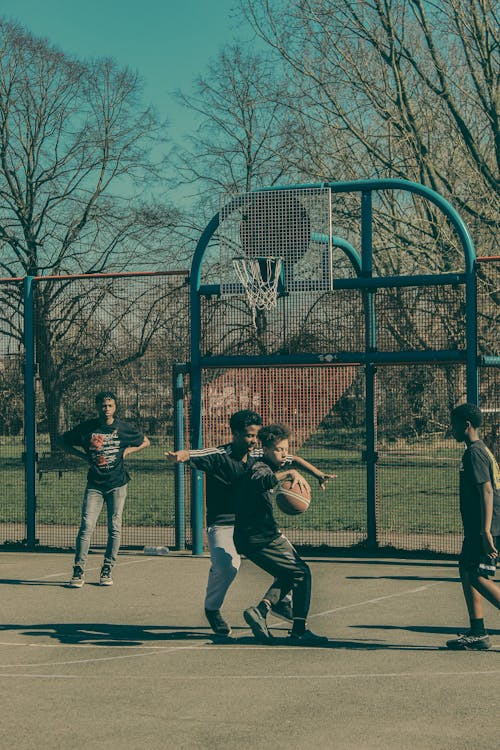 Boys Playing Basketball Outdoors 