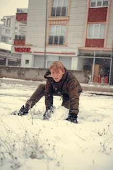 A child having fun in the snow outside in winter, embracing the cold weather.