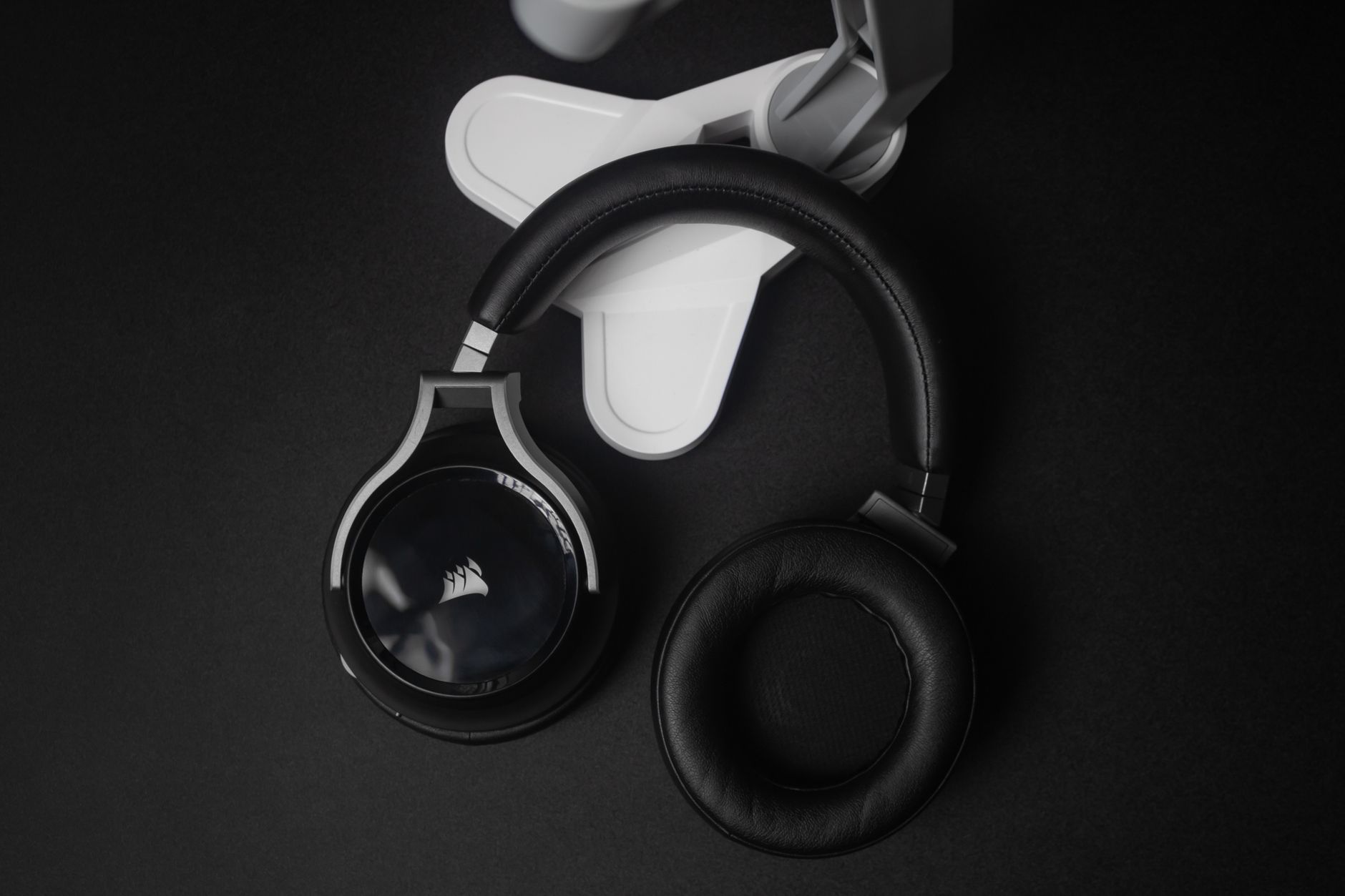 Modern black stereo headphones on a black background, perfect for tech and music themes.