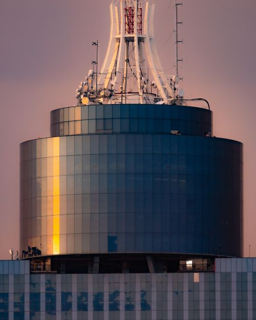 Free Close-up of a modern skyscraper rooftop against a sunset sky. Stock Photo