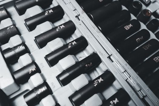 Detailed view of a black and white industrial socket set neatly arranged in a toolbox.