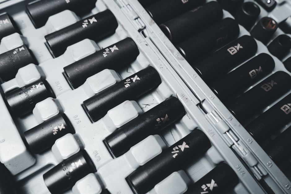 Detailed view of a black and white industrial socket set neatly arranged in a toolbox.