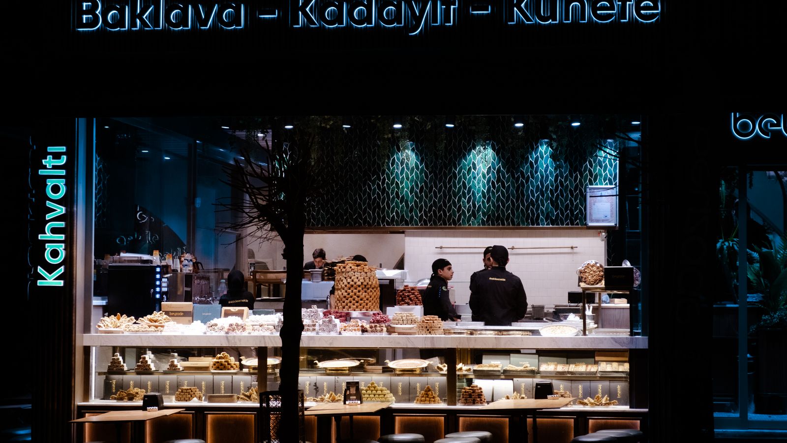 Night view of a bakery café showcasing traditional sweets with illuminated display.