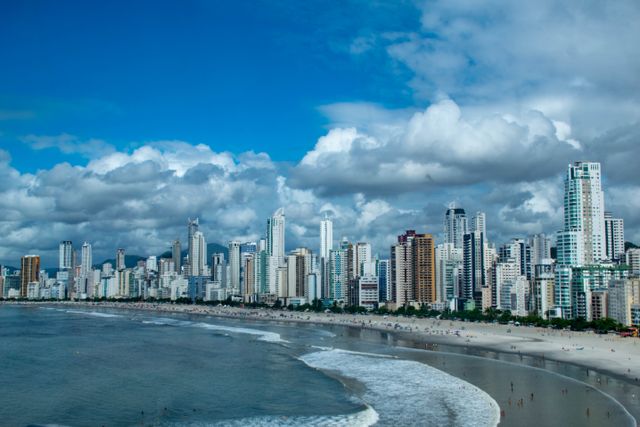 Captivating city skyline against a vibrant beach and sea, featuring towering skyscrapers and a dynamic oceanfront.
