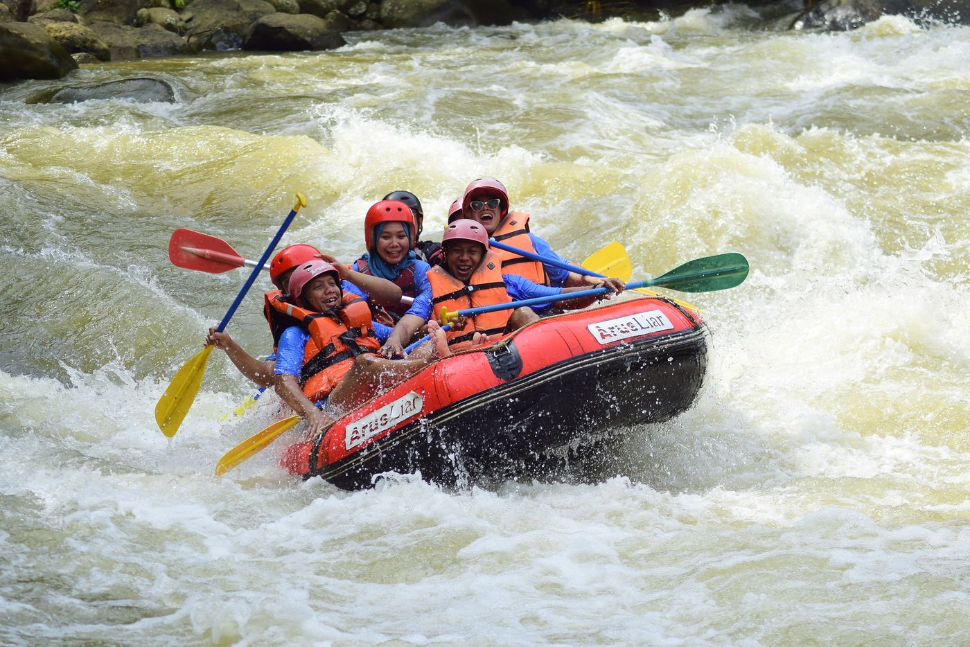 Group wearing helmets and life jackets during whitewater rafting