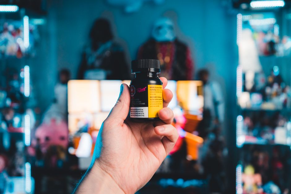 A shopper turning a supplement bottle over to read the ingredient label in a store