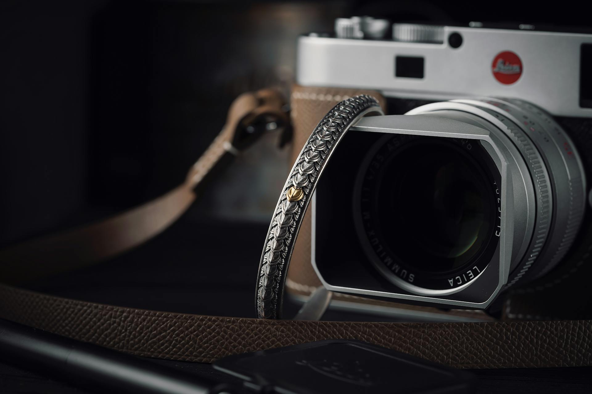 Elegant camera setup with handmade strap and lens cap, perfect for photography enthusiasts.