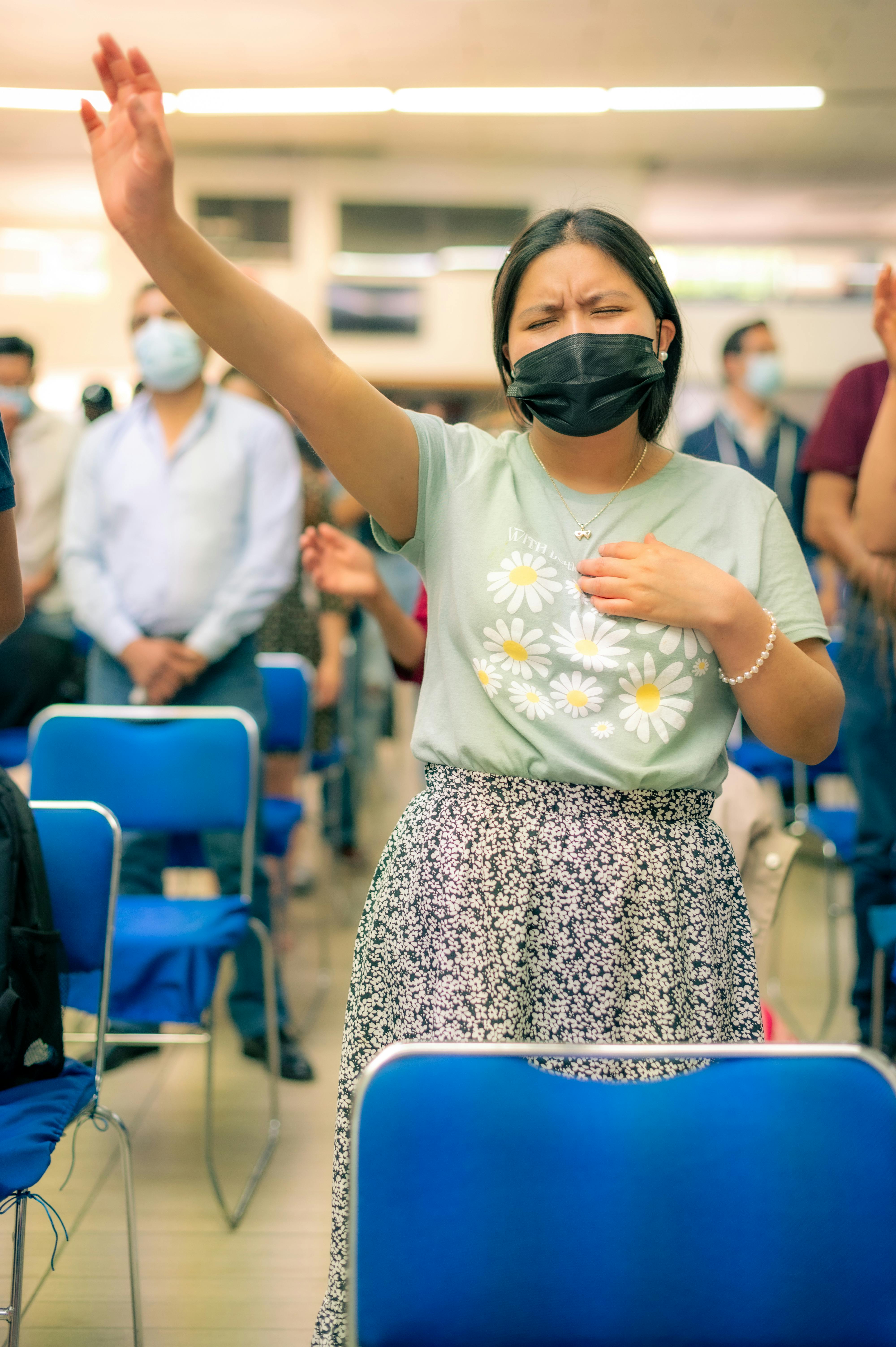 woman with closed eyes raising her arm