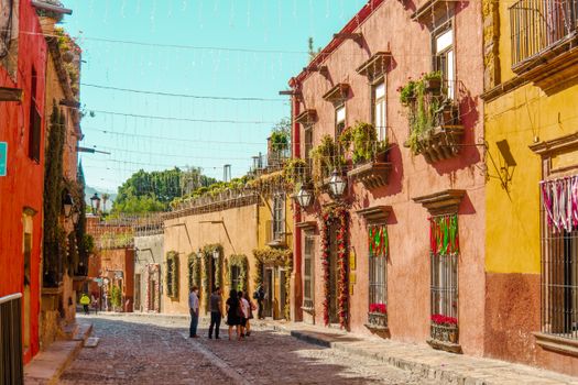 Vibrant street scene in San Miguel de Allende featuring colorful buildings and cobblestone pathways.