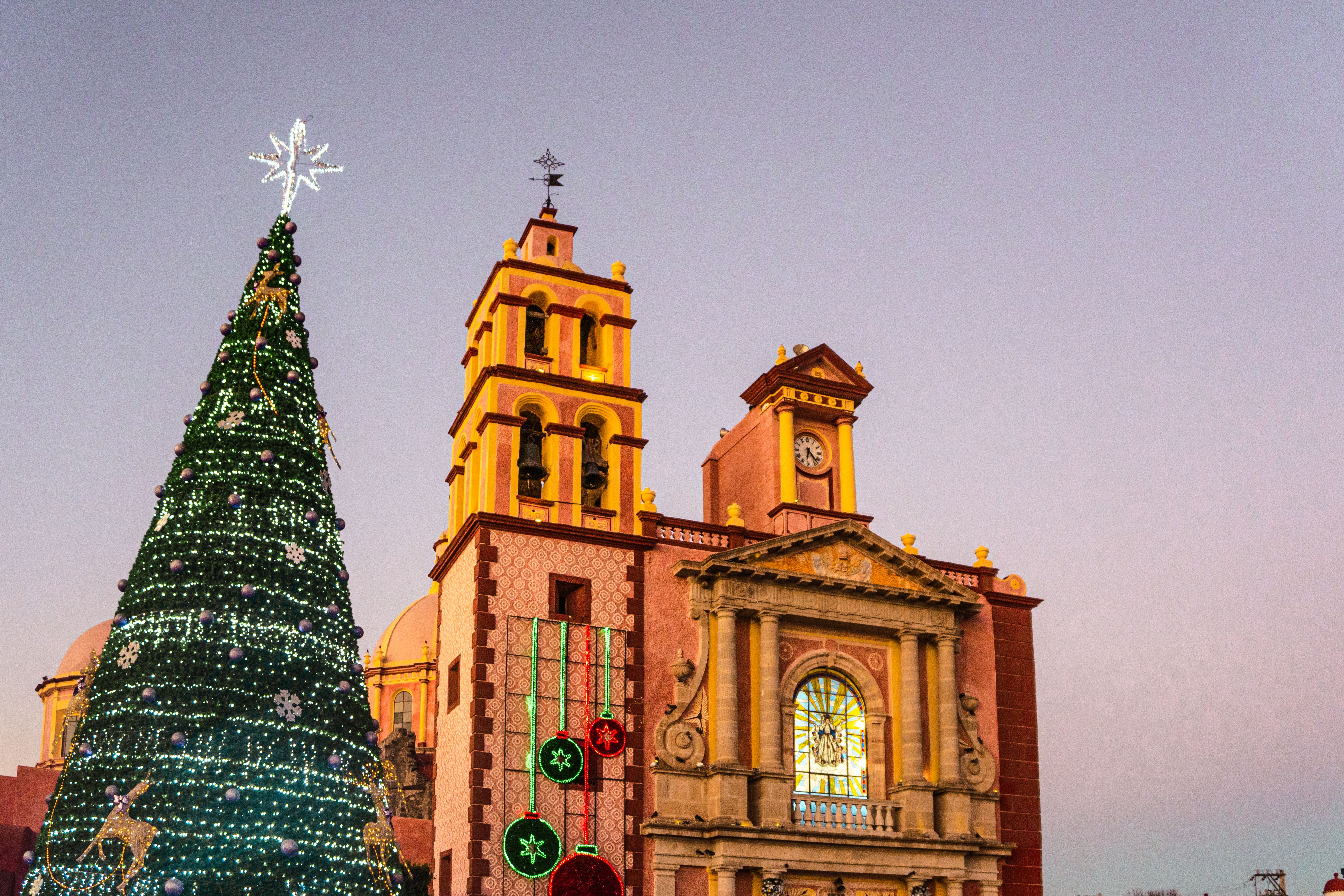 Sapin de Noël décoré devant une église coloniale mexicaine au coucher du soleil