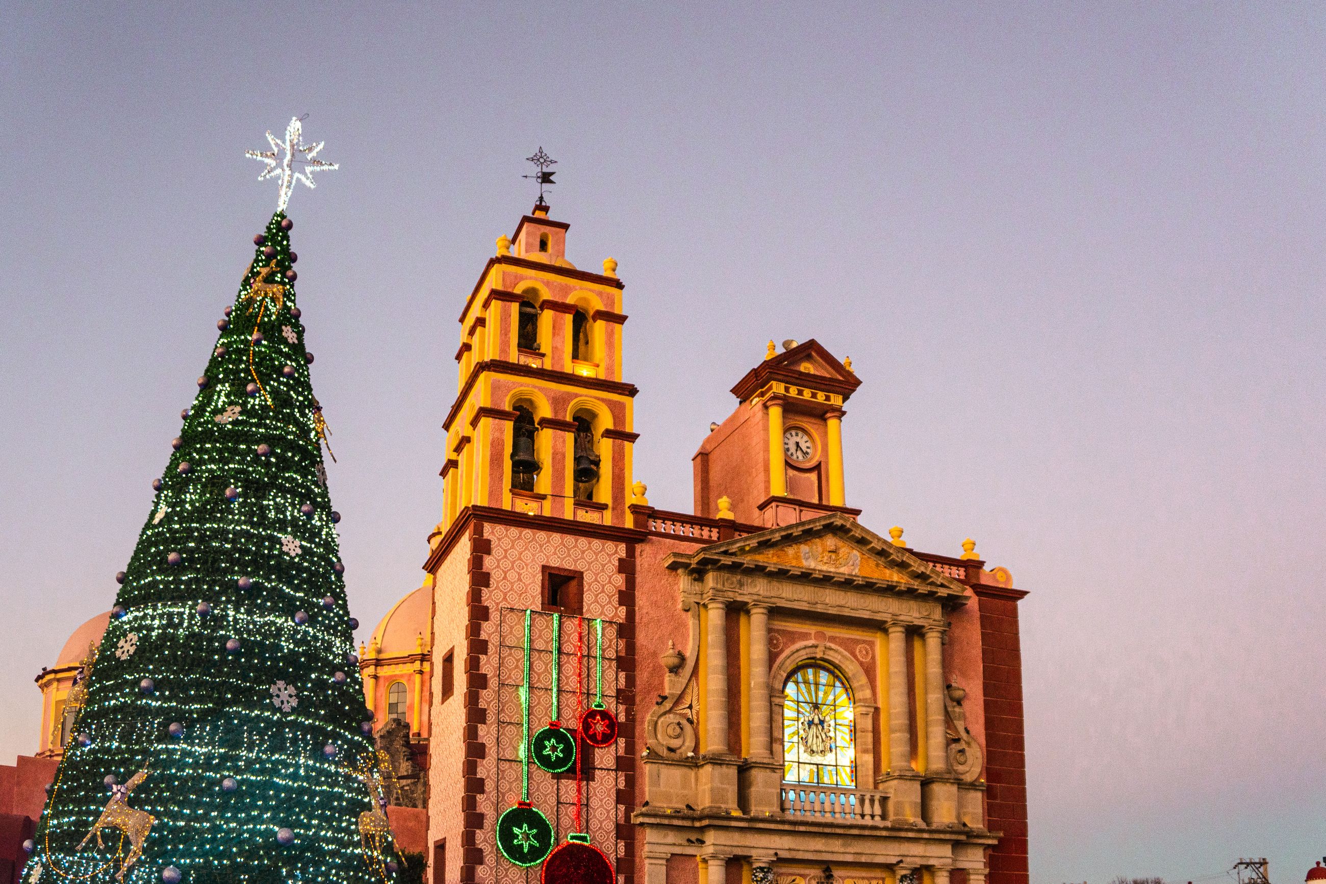 Sapin de Noël décoré devant une église coloniale mexicaine au coucher du soleil