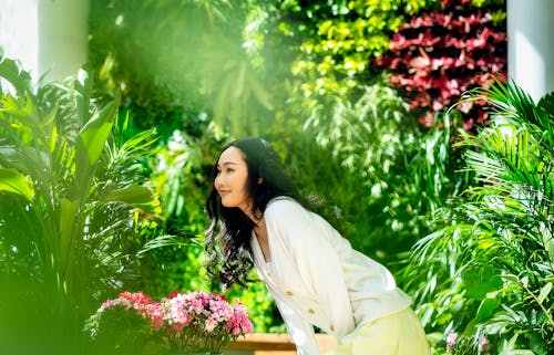 Smiling Woman Posing among Green Plants