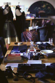 Explore a bustling fashion workshop filled with tools and fabrics, showcasing creative design elements.