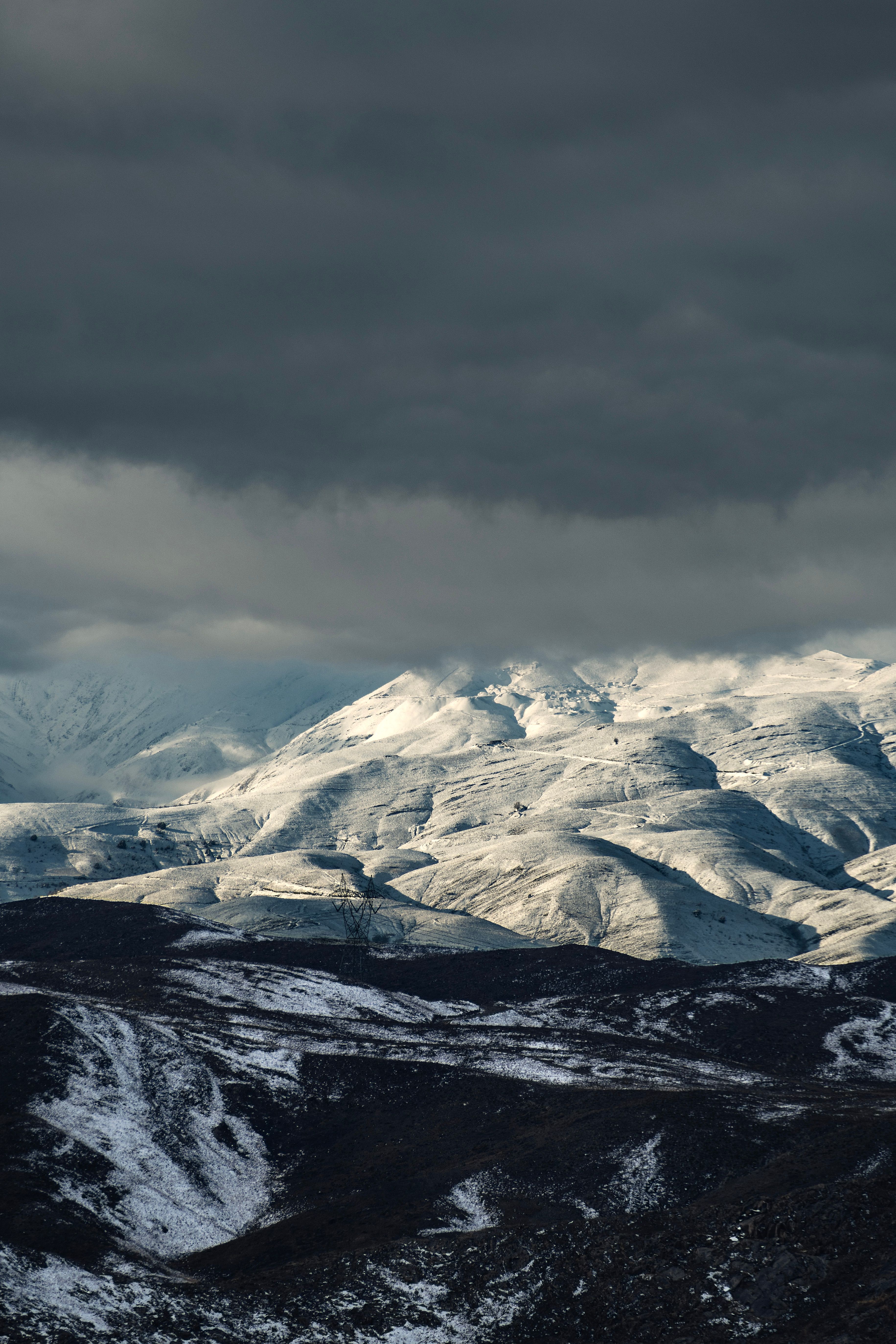 A snowy mountain range with a dark sky above · Free Stock Photo
