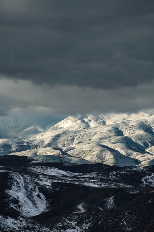 Free Captivating winter view of snowy mountains under dramatic clouds in Mashhad, Iran. Stock Photo