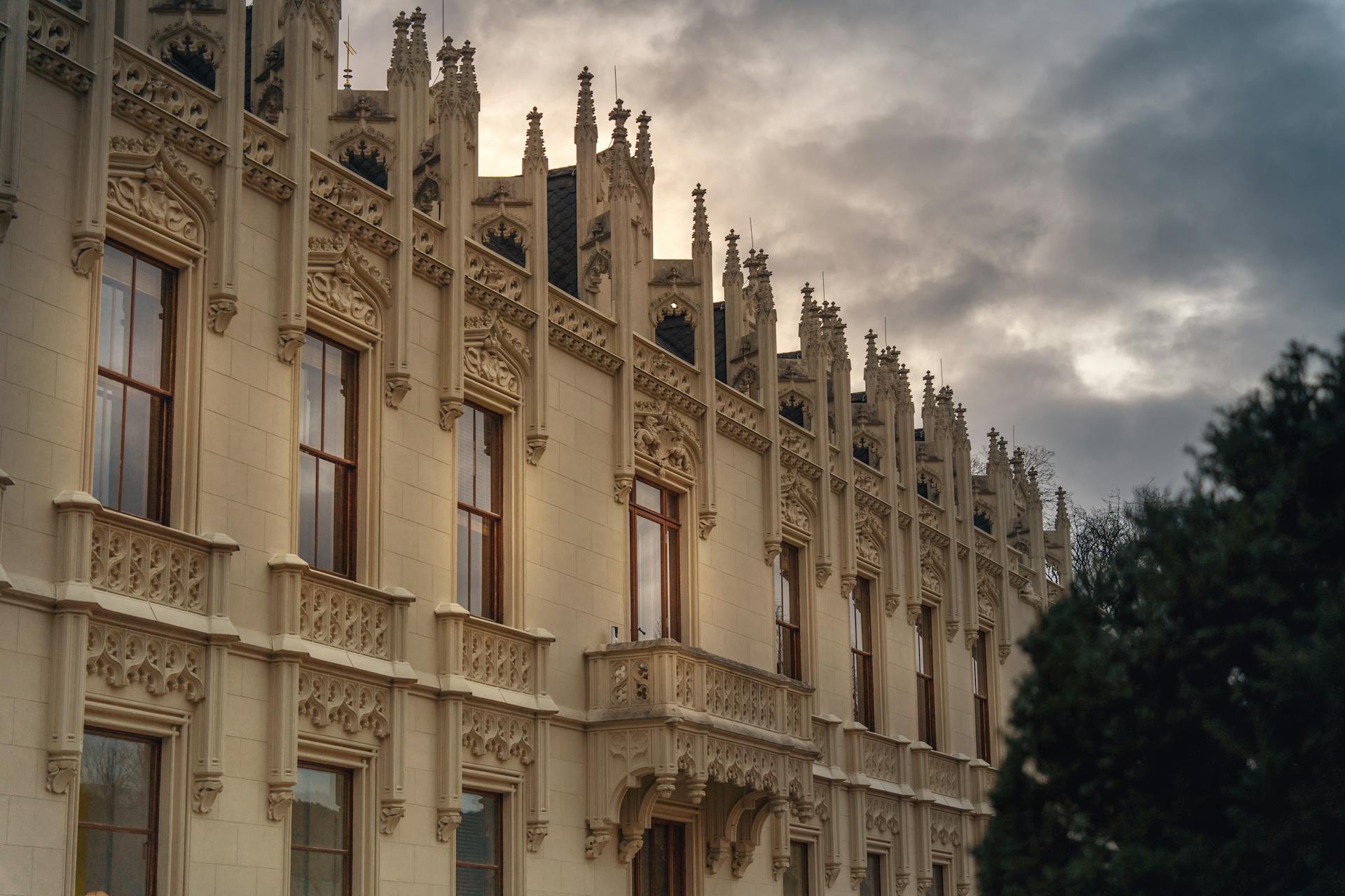 Ornate Gothic Revival building facade in Vienna, Austria during an overcast evening.